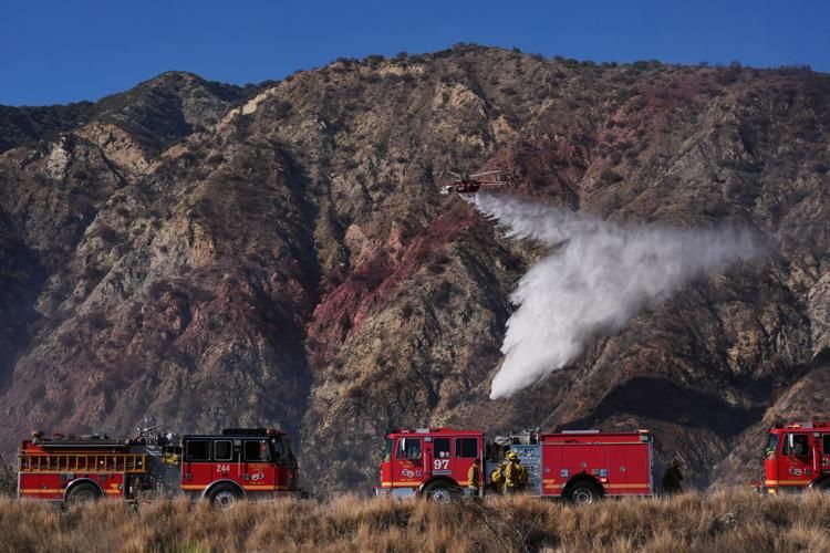 Wildfires burn in Southern California as utilities cut power to thousands