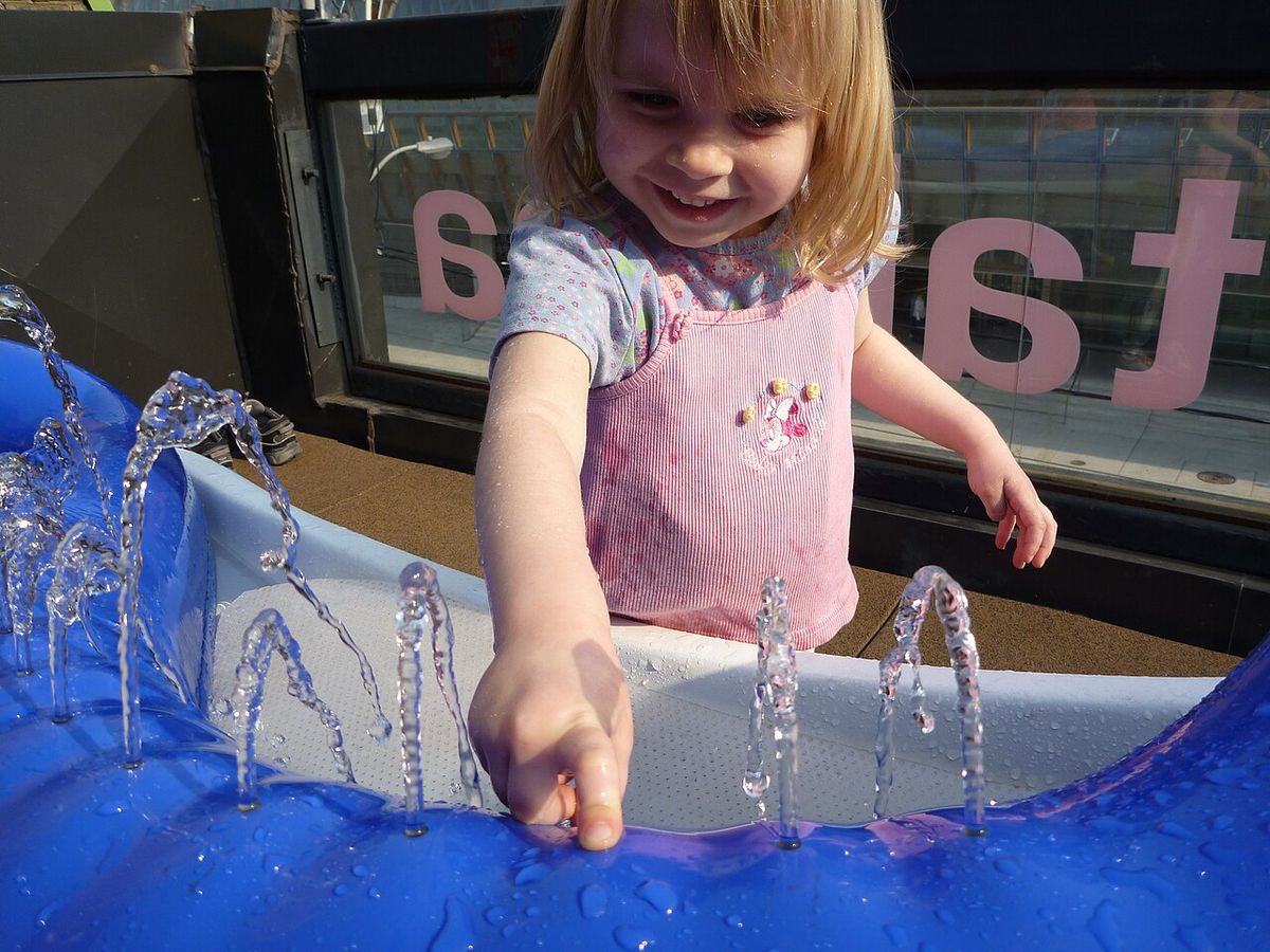 A young musician plays on a hydraulophone, the world's first instrument that makes music with water.