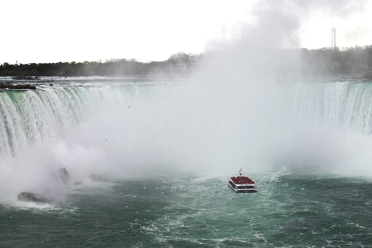 Horseshoe falls from Niagara Falls, Ontario, with a red City Cruises Canada viewing boat.